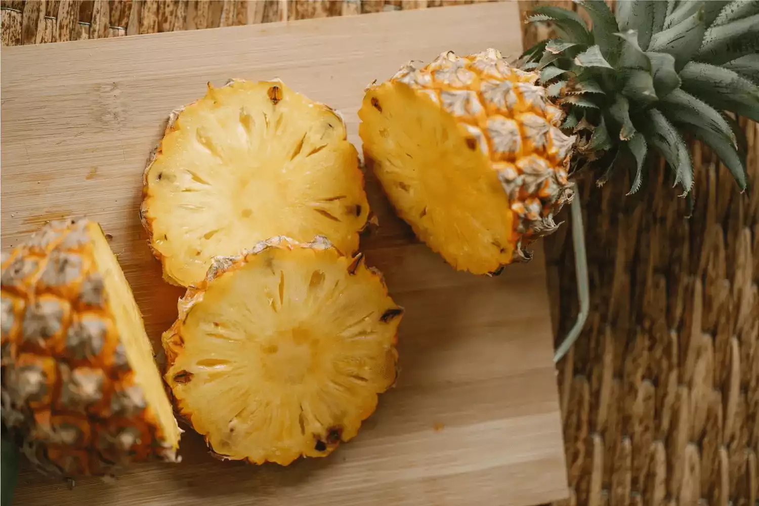 Sur cette image il y a des ananas sur une planche à découpé.